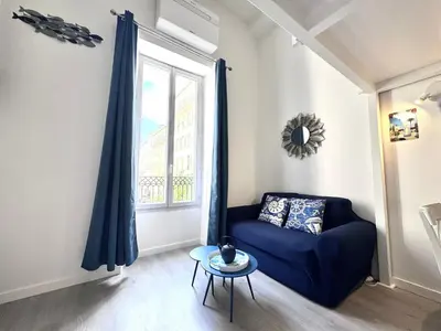 a mirror on the wall above a couch with pillows at NICE - Duplex Carré d'Or - 100m promenade des Anglais in Nice