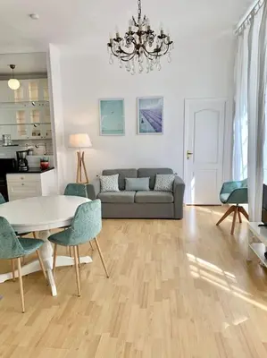 a living room with a couch and a table and chairs at Saint Philippe - T3 près de la plage in Nice