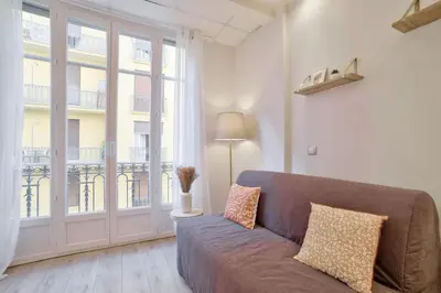 a living room with a couch and a large window at 12 Trachel - T2 lumineux au coeur de Nice in Nice