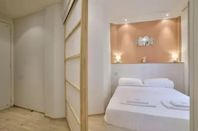 a bedroom with a large white bed and a mirror at 12 Trachel - T2 lumineux au coeur de Nice in Nice