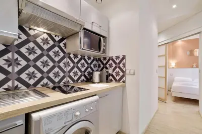 a kitchen with a stove and a washer and dryer at 12 Trachel - T2 lumineux au coeur de Nice in Nice