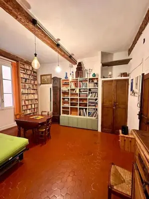 a large room with a table and chairs and a library at Abbaye - Appartement spacieux au coeur du Vieux-Nice in Nice
