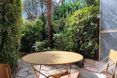 a table and chairs on a patio with trees at Ratti - Studio avec jardin au coeur de Nice in Nice