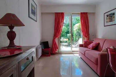 a living room with a red couch and a window at Ratti - Studio avec jardin au coeur de Nice in Nice