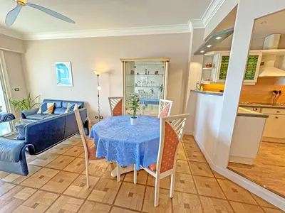 a living room with a table and a kitchen at Cosy Sea Front Apartment Nice France in Nice