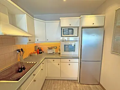 a kitchen with white cabinets and a stainless steel refrigerator at Cosy Sea Front Apartment Nice France in Nice