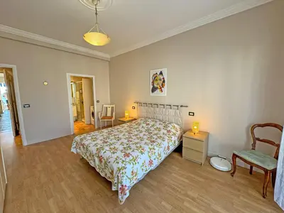 a bedroom with a bed and a chair at Cosy Sea Front Apartment Nice France in Nice