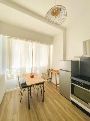 a small kitchen with a table and a refrigerator at Alsace Lorraine - Wifi, 3 pers, hyper centre in Nice