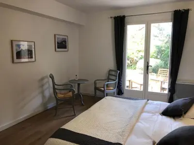 a bedroom with a bed and a table and chairs at Villa de Charme au coeur du Cap-Ferrat in Saint-Jean-Cap-Ferrat