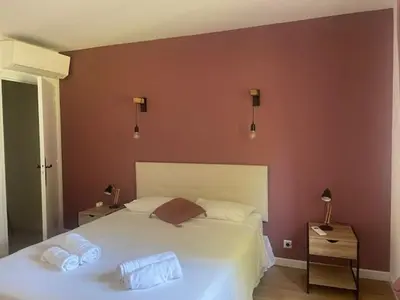 a bedroom with a large white bed with two pillows at Villa de Charme au coeur du Cap-Ferrat in Saint-Jean-Cap-Ferrat