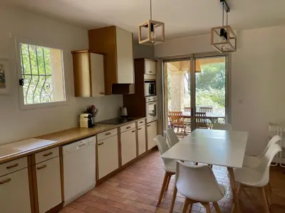 a kitchen with a table and a table and chairs at Villa de Charme au coeur du Cap-Ferrat in Saint-Jean-Cap-Ferrat