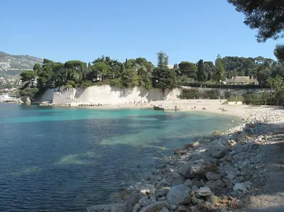 a beach with a bunch of people in the water at Villa de Charme au coeur du Cap-Ferrat in Saint-Jean-Cap-Ferrat