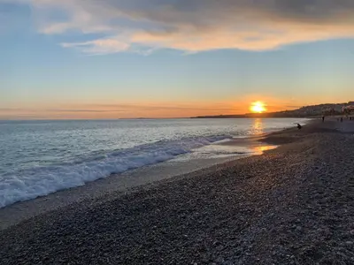 a sunset on a beach with the ocean at Appartement à 1 min de la plage in Nice