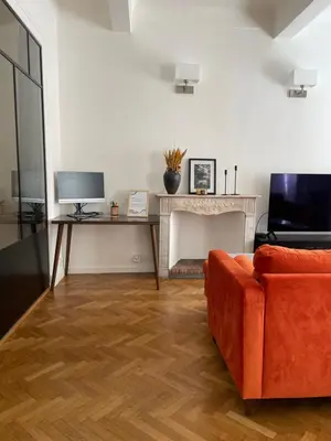 a living room with a couch and a table with a television at Appartement à 1 min de la plage in Nice