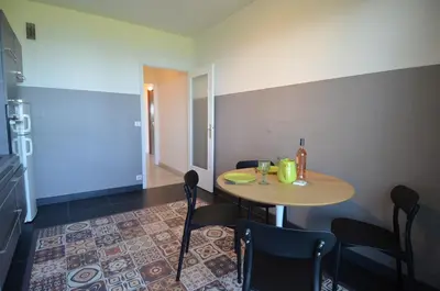 a room with a table and chairs and a kitchen at SIRIUS - Exceptionnelle vue mer dans les hauteurs de Nice in Nice