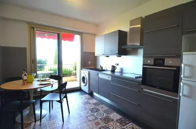 a kitchen with a table and a dining room at SIRIUS - Exceptionnelle vue mer dans les hauteurs de Nice in Nice