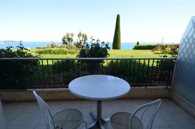 a white table and chairs on a balcony with the ocean at SIRIUS - Exceptionnelle vue mer dans les hauteurs de Nice in Nice