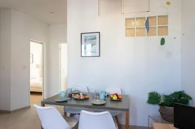 a dining room with a table and white chairs at #21 2 Bdr balconies 10 mins walk to sea 5mins to tram in Nice