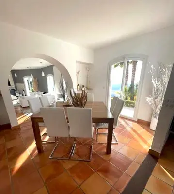a dining room with a table and white chairs at Maison charmante à Aspremont avec piscine privative in Aspremont