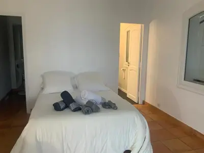a bedroom with a white bed with shoes on it at Maison charmante à Aspremont avec piscine privative in Aspremont