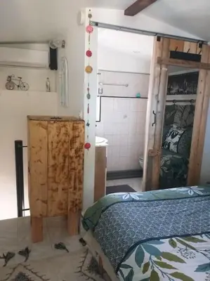 a bedroom with a bed and a bathroom at Au lit, on dort in Cantaron