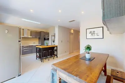 a kitchen and dining room with a wooden table at Villa La Roche aux Mouettes FSHH in Nice
