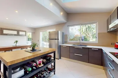 a kitchen with a refrigerator and a counter with wine bottles at Villa La Roche aux Mouettes FSHH in Nice