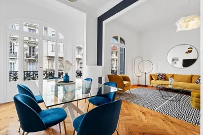a living room with a glass table and blue chairs at Nice Renting - FOCH - Luxury Bourgeois & Design at the Heart of Nice in Nice