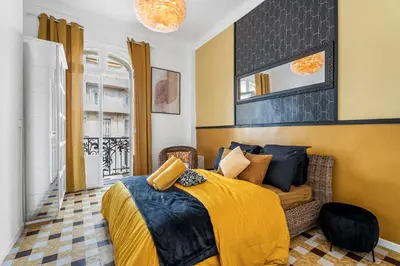 a bedroom with a bed with a yellow blanket at Nice Renting - FOCH - Luxury Bourgeois & Design at the Heart of Nice in Nice