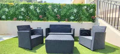 three chairs and a table on a patio with grass at 2p bas de Villa avec Jacuzzi privatif proche de Nice in Saint-Laurent-du-Var