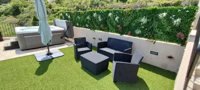 a patio with chairs and a table and an umbrella at 2p bas de Villa avec Jacuzzi privatif proche de Nice in Saint-Laurent-du-Var