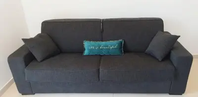 a blue couch with a blue pillow on it at 2p bas de Villa avec Jacuzzi privatif proche de Nice in Saint-Laurent-du-Var