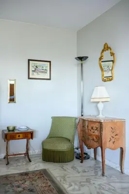 a room with a chair and a table and a lamp at Nice Absea Belles Terres C in Nice