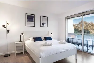 a white bedroom with a bed and a large window at Nice Absea Belles Terres in Nice
