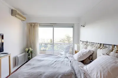 a white bedroom with a bed and a window at Nice Absea Belles Terres 5 in Nice