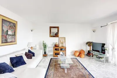 a white living room with a white couch and a tv at Nice Absea Belles Terres 5 in Nice