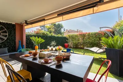 a patio with a table with food on it at DOMAINE DES ROSES 3 AP4400 By Riviera Holiday Home in Nice