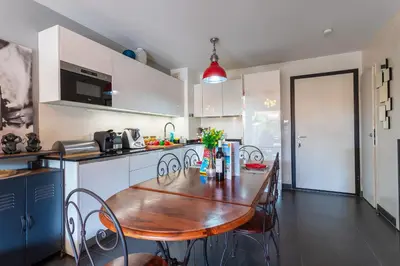 a kitchen with a wooden table and chairs in it at DOMAINE DES ROSES 3 AP4400 By Riviera Holiday Home in Nice