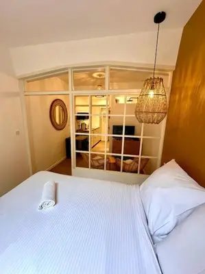 a bedroom with a white bed and a window at Rue Droite - Studio cosy au coeur du Vieux-Nice in Nice