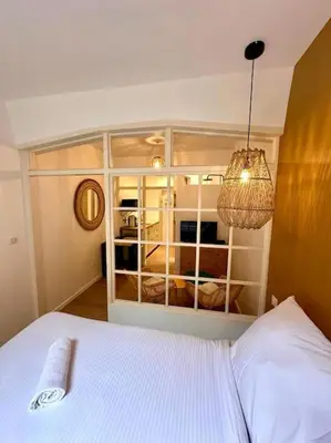 a bedroom with a white bed and a large window at Rue Droite - Studio cosy au coeur du Vieux-Nice in Nice