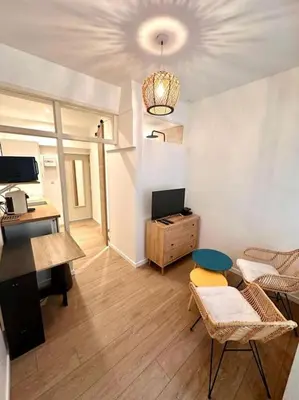a living room with a desk and chairs and a table at Rue Droite - Studio cosy au coeur du Vieux-Nice in Nice