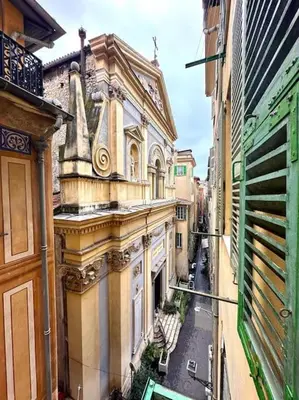 an old building with a letter on the side of it at Rue Droite - Studio cosy au coeur du Vieux-Nice in Nice