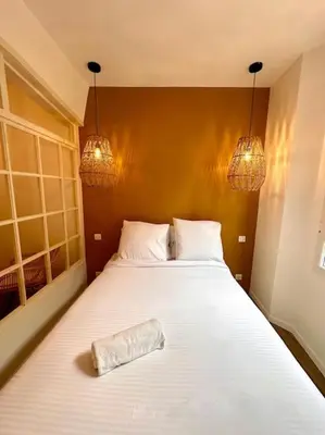 a bed in a bedroom with two lights and a pillow on it at Rue Droite - Studio cosy au coeur du Vieux-Nice in Nice