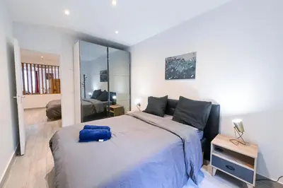 a bedroom with a large bed with a blue pillow on it at Loft place Masséna avec terrasse in Nice