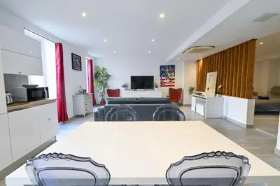 a kitchen and living room with a table and chairs at Loft place Masséna avec terrasse in Nice