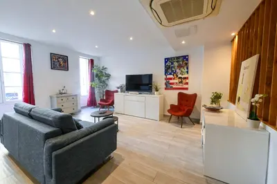 a living room with a couch and a tv at Loft place Masséna avec terrasse in Nice