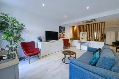 a living room with a blue couch and red chairs at Loft place Masséna avec terrasse in Nice