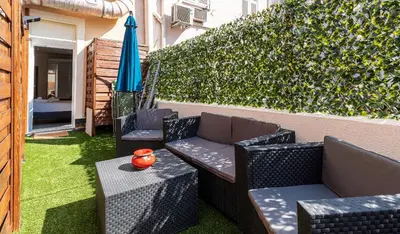 a patio with two chairs and a table and an umbrella at Loft place Masséna avec terrasse in Nice