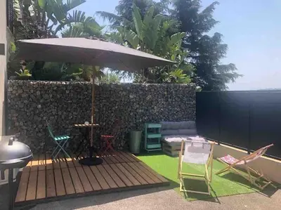 a patio with a table and an umbrella and chairs at AmorePP Studio design près Stade Allianz Riviera in Nice