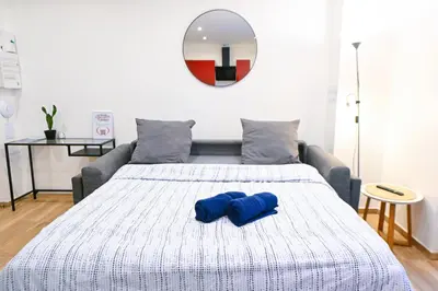 a bed with two blue pillows on top of it at Beau studio cozy centre ville et plages avec terrasse n3 in Nice